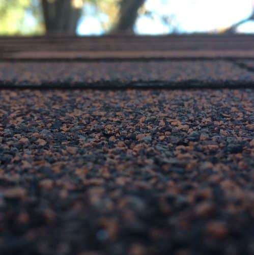 Hailstones scattered across an asphalt shingle roof after a storm