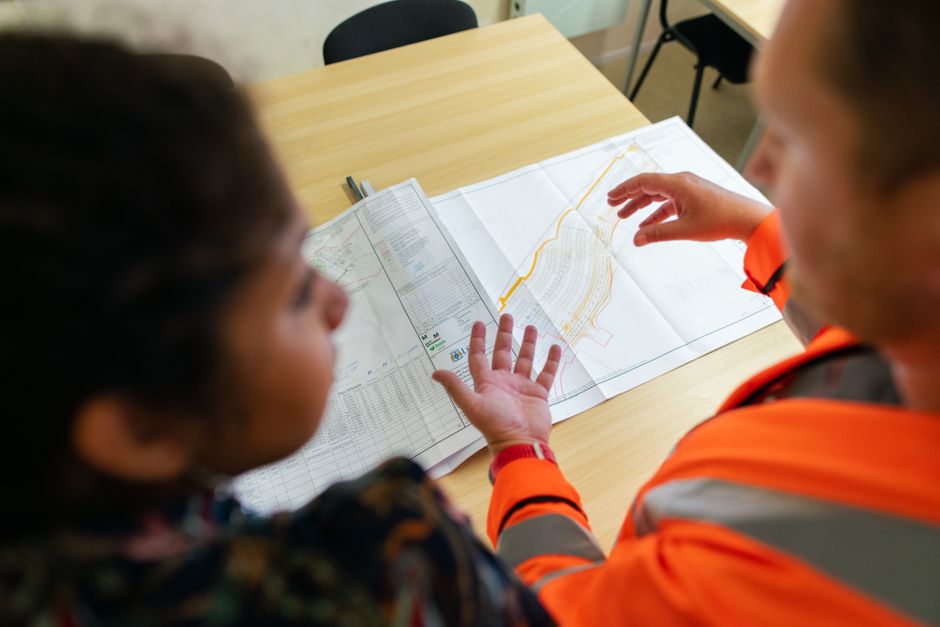 Contractor pointing out details on a printed roofing estimate