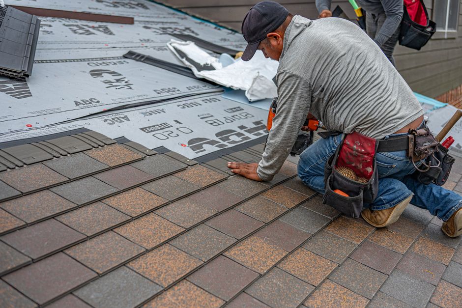 Inspector checking shingles and flashing on a roof before a home sale